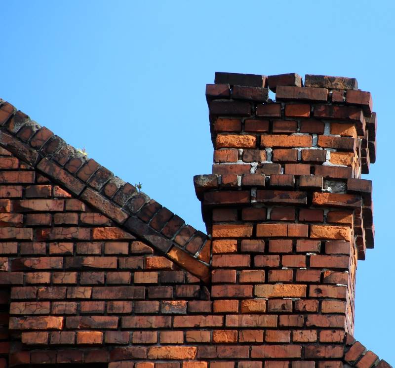 Signs Your Hillside Home Needs a Chimney Inspection Damaged chimney on an Hillside home showing cracks and missing mortar